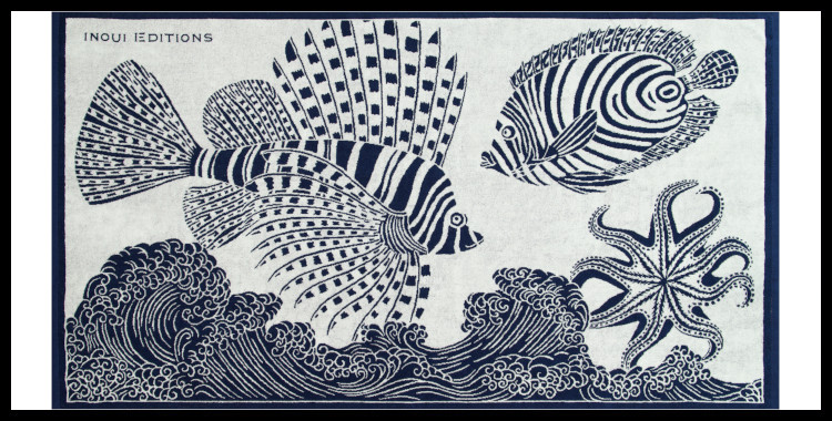 Serviette éponge, inoui éditions représente des poissons et des vagues, en blanc et bleu marine.
